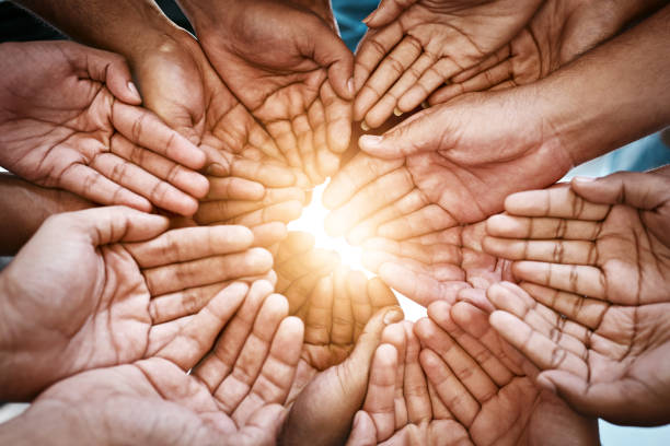 Cropped shot of a diverse group of people holding out their cupped hands Cropped shot of a diverse group of people holding out their cupped hands
