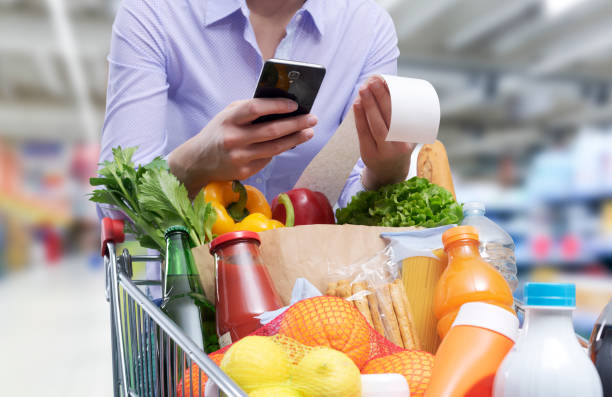 Woman checking the grocery receipt using her smartphone Woman checking the grocery receipt using her smartphone